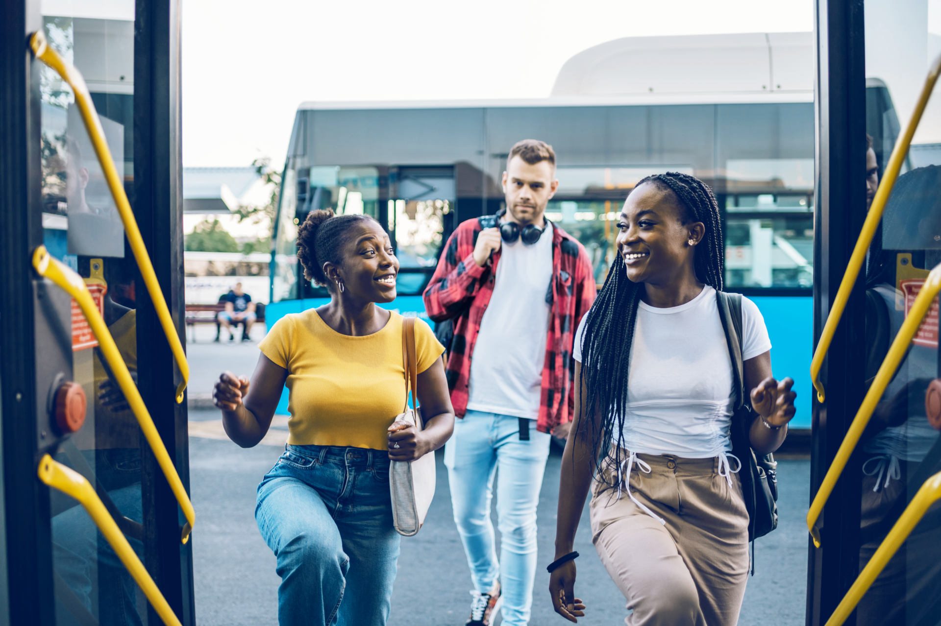 Jeunes personnes souriantes entrant dans un bus.